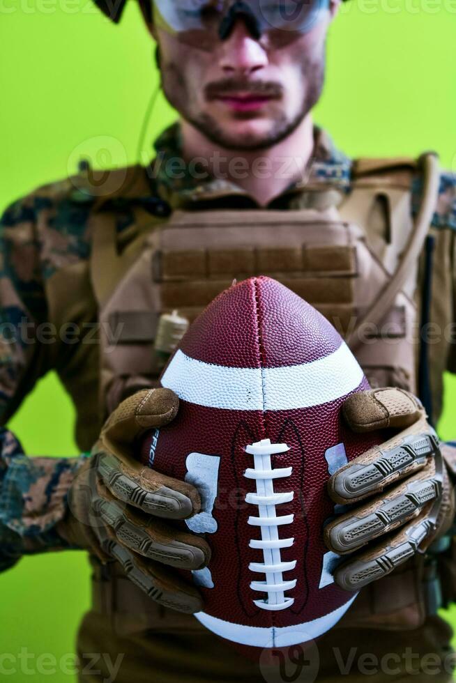 solder holding american football ball photo