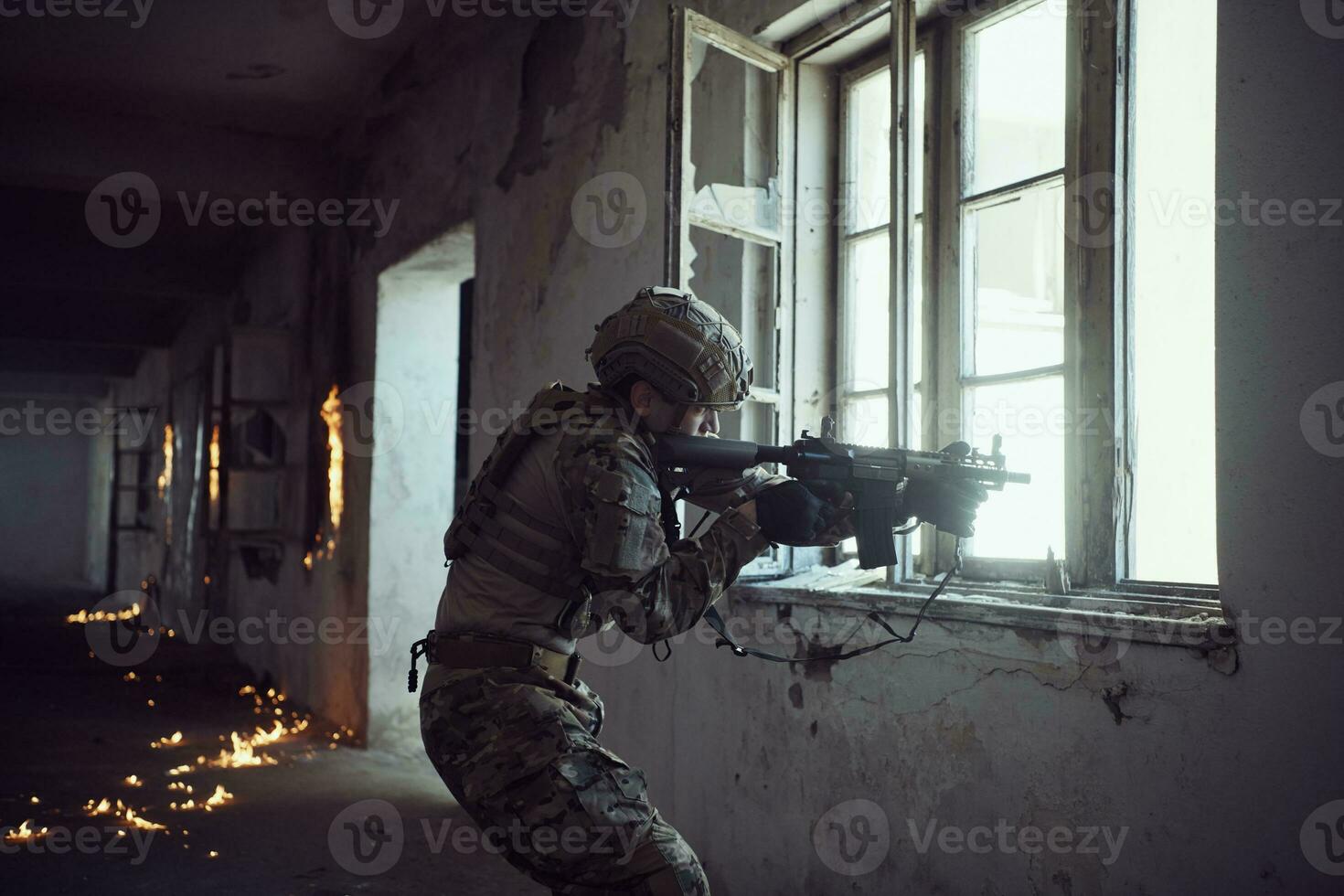 soldier in action near window changing magazine and take cover photo