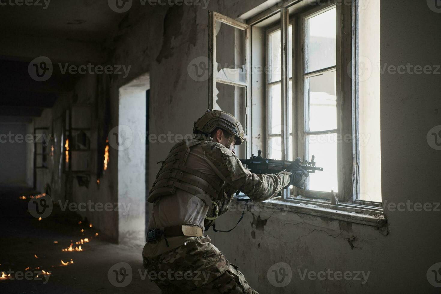 soldier in action near window changing magazine and take cover photo