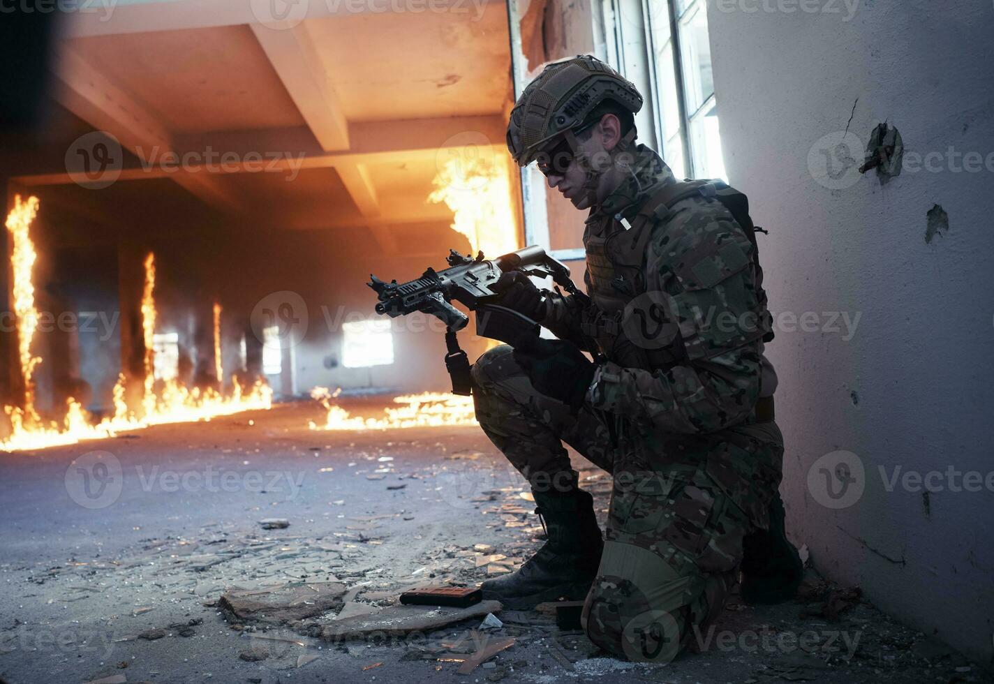 soldier in action near window changing magazine and take cover photo