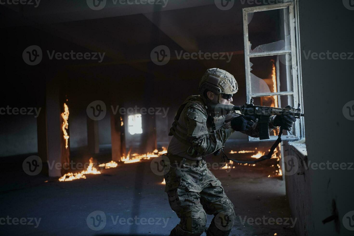 soldier in action near window changing magazine and take cover photo