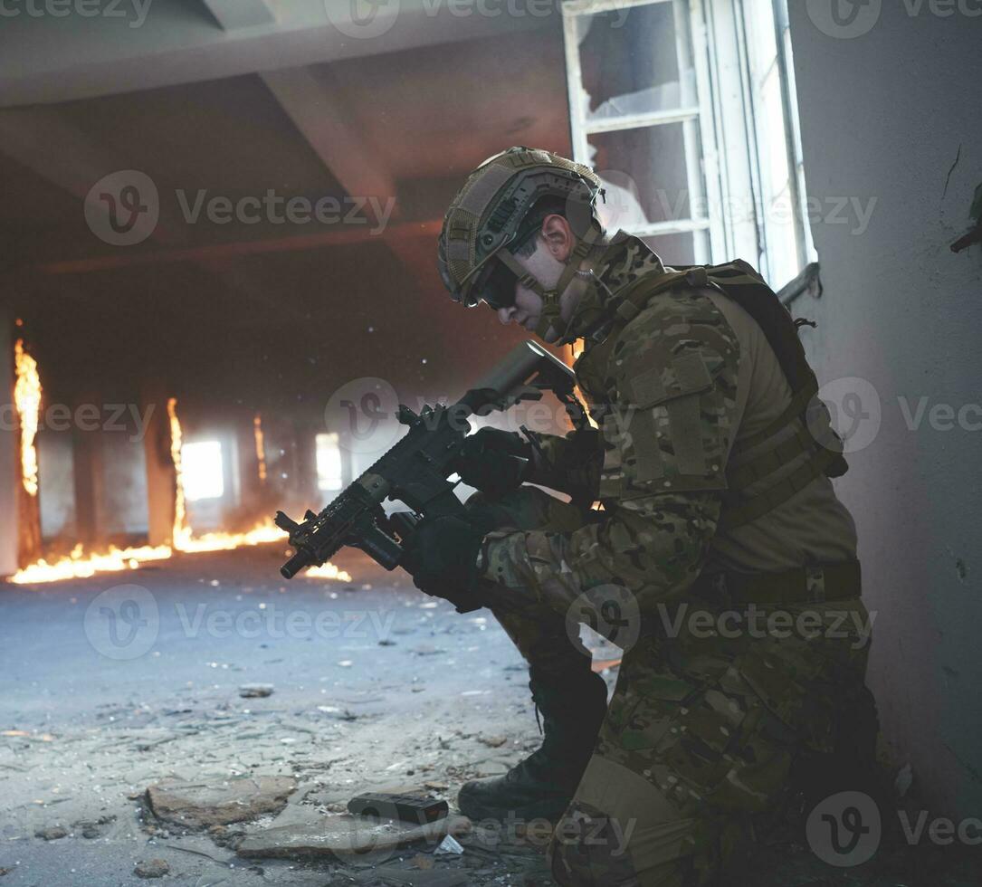 soldier in action near window changing magazine and take cover photo