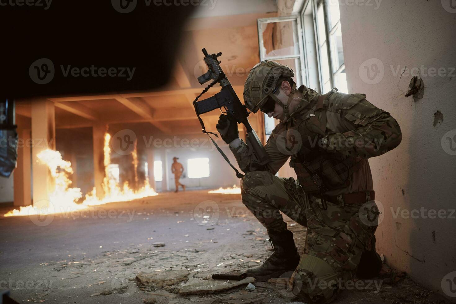soldier in action near window changing magazine and take cover photo
