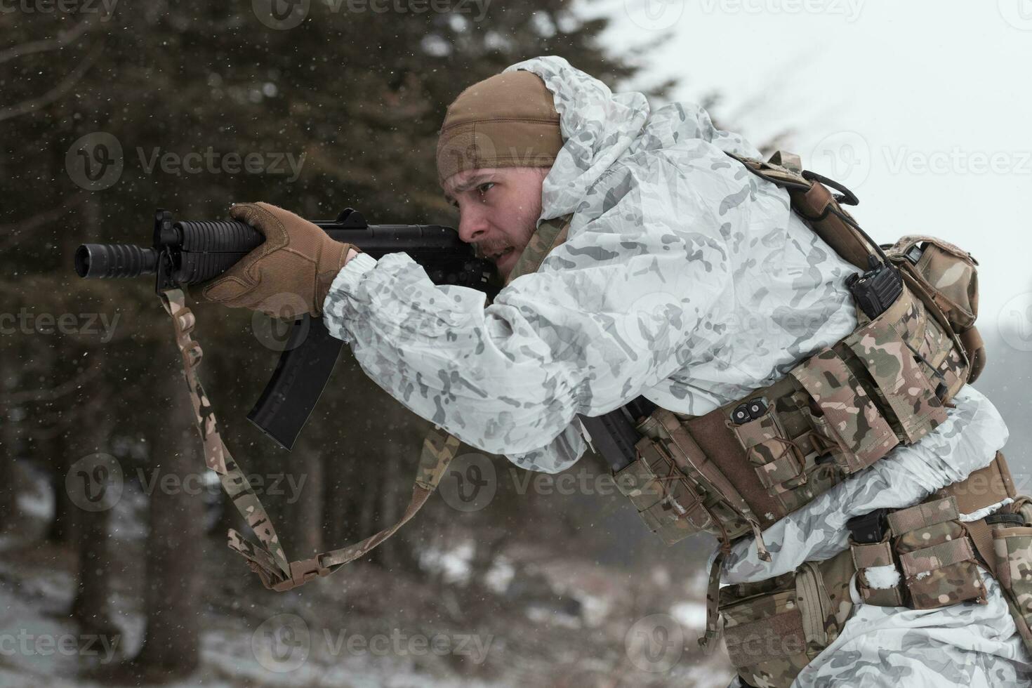 guerra de invierno en las montañas árticas. operación en condiciones frías. soldado en uniforme camuflado de invierno en el ejército de guerra moderno en un día de nieve en el campo de batalla del bosque con un rifle. enfoque selectivo foto