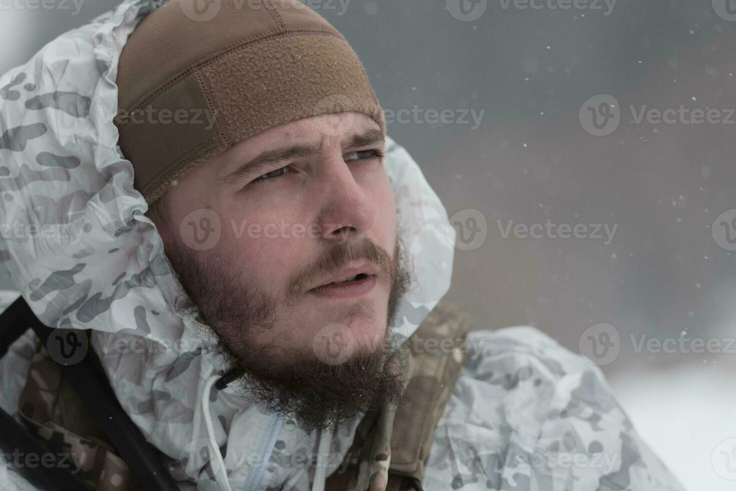 Winter war in the Arctic mountains. Operation in cold conditions.Soldier in winter camouflaged uniform in Modern warfare army on a snow day on forest battlefield with a rifle. Selective focus photo