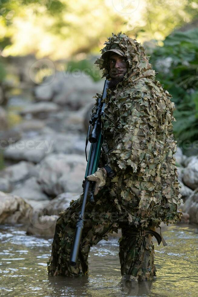 un militar hombre o airsoft jugador en un camuflaje traje furtivo el río y  objetivos desde un francotirador rifle a el lado o a objetivo. 31053741  Foto de stock en Vecteezy