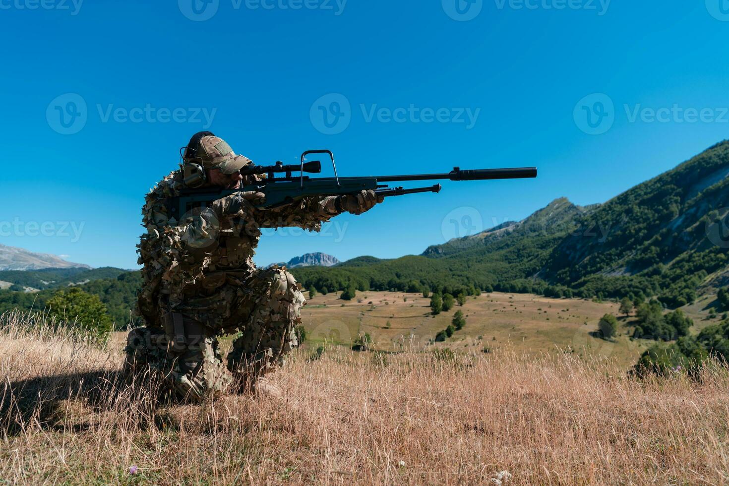 army soldier holding sniper rifle with scope and aiming in forest. war, army, technology and people concept photo