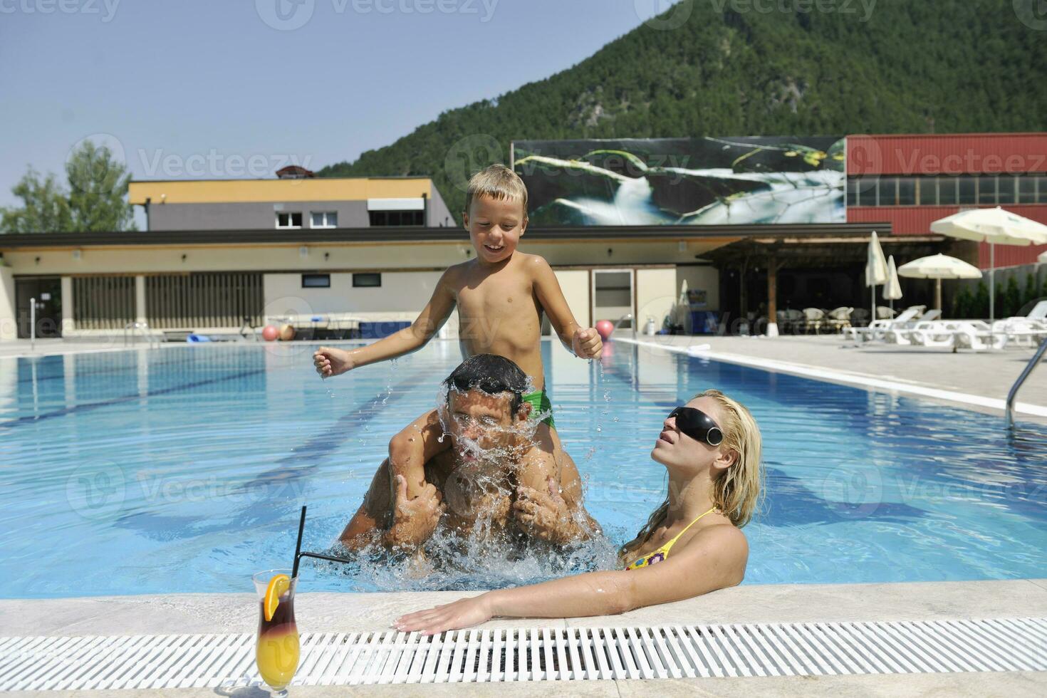 happy young family have fun on swimming pool photo