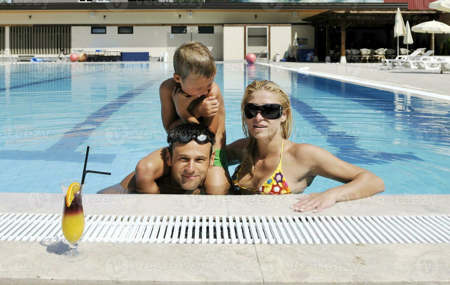 happy young family have fun on swimming pool photo