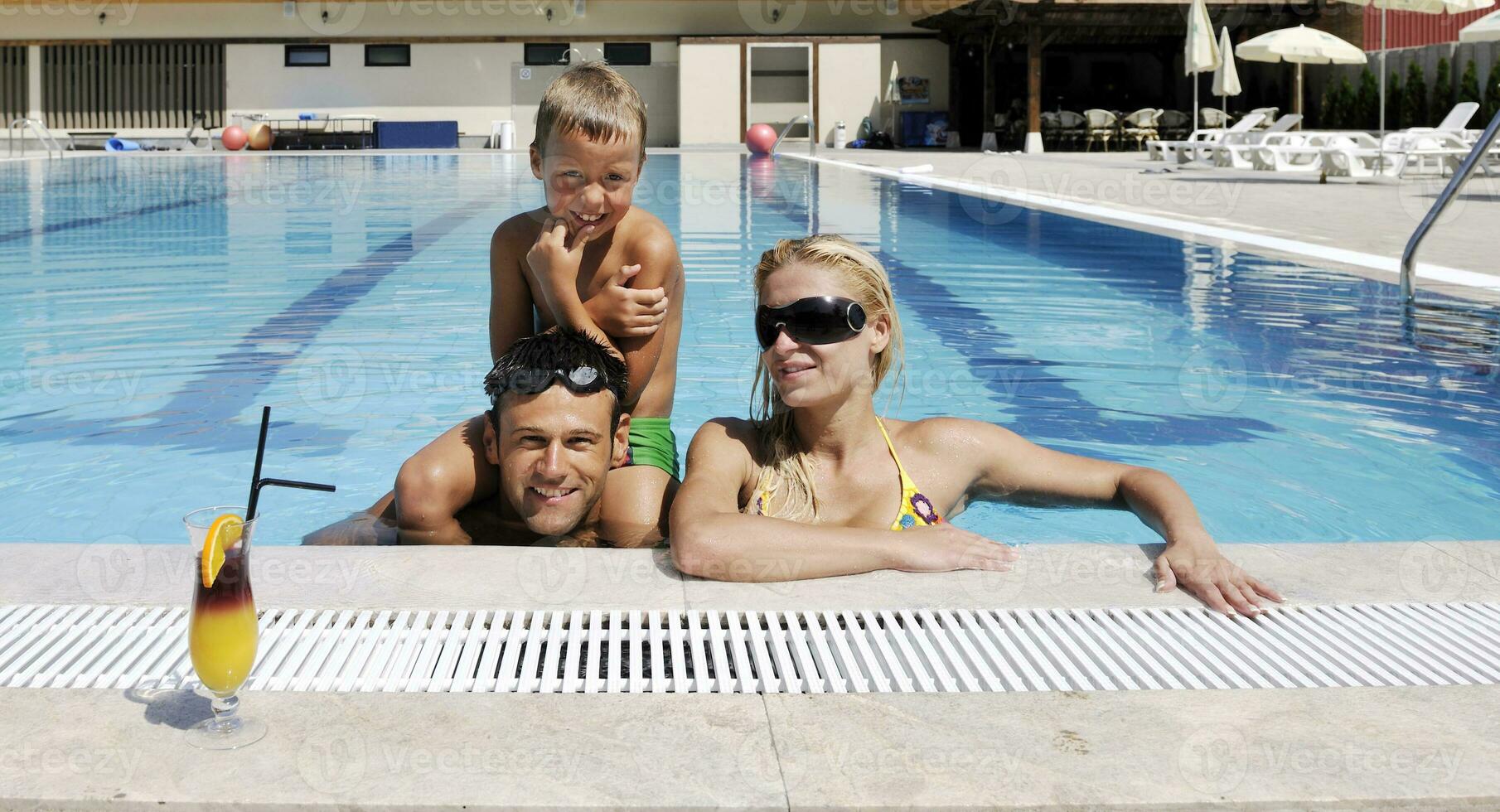 happy young family have fun on swimming pool photo