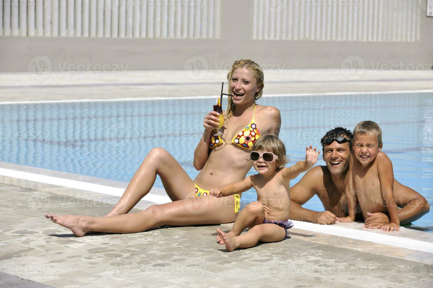 happy young family have fun on swimming pool photo