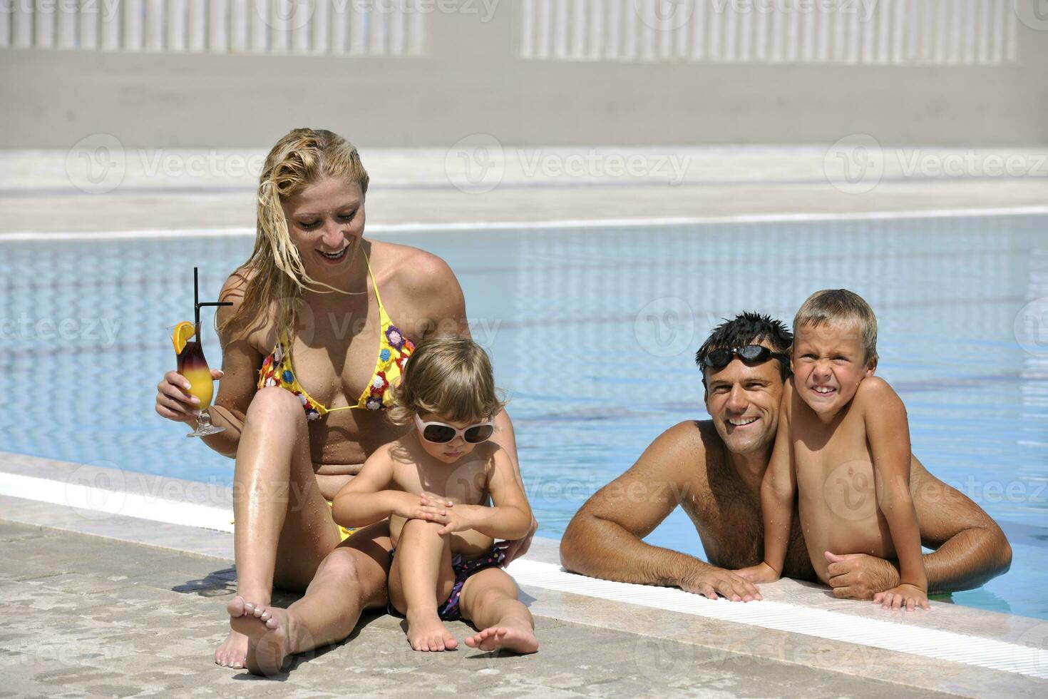 happy young family have fun on swimming pool photo