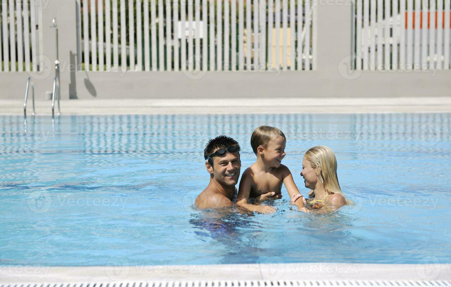 happy young family have fun on swimming pool photo