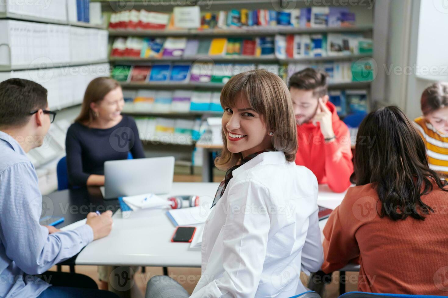 students group working on school project together on tablet computer at modern university photo