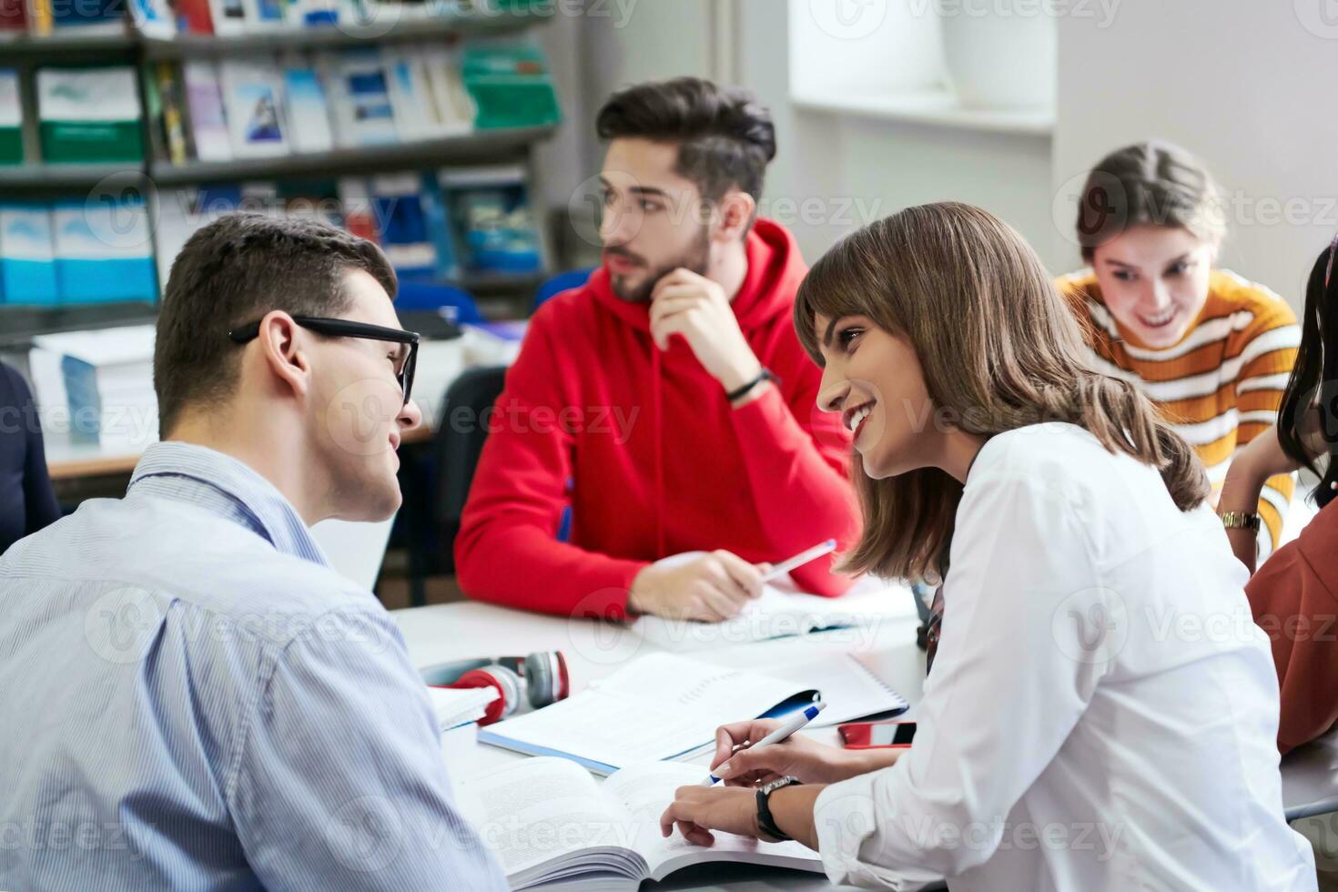 students group working on school project together on tablet computer at modern university photo