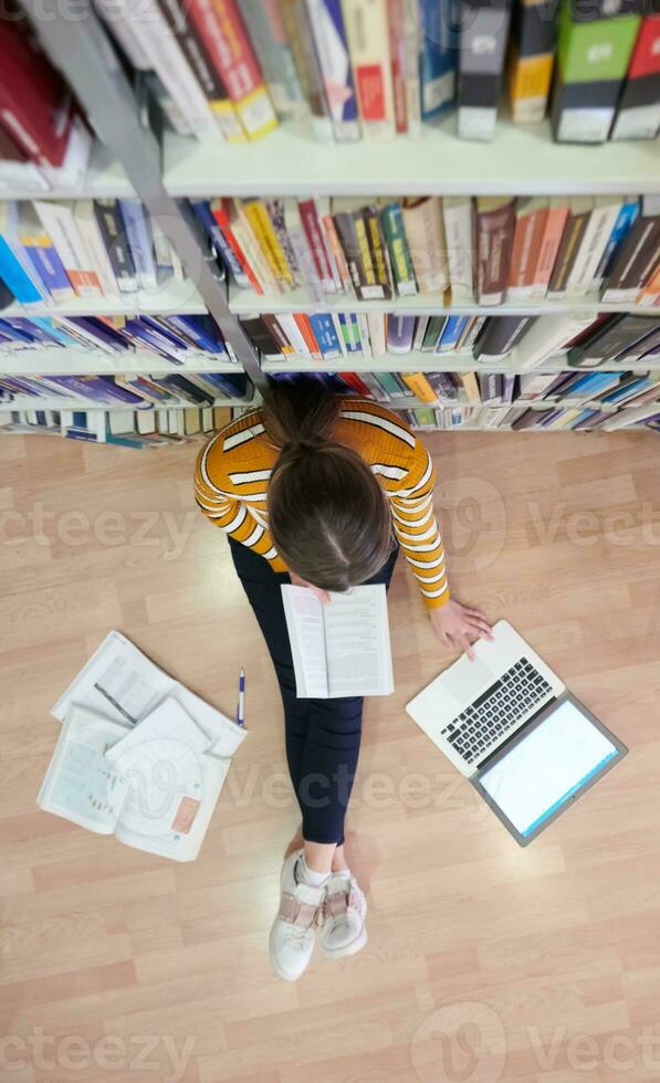 the student uses a notebook and a school library photo