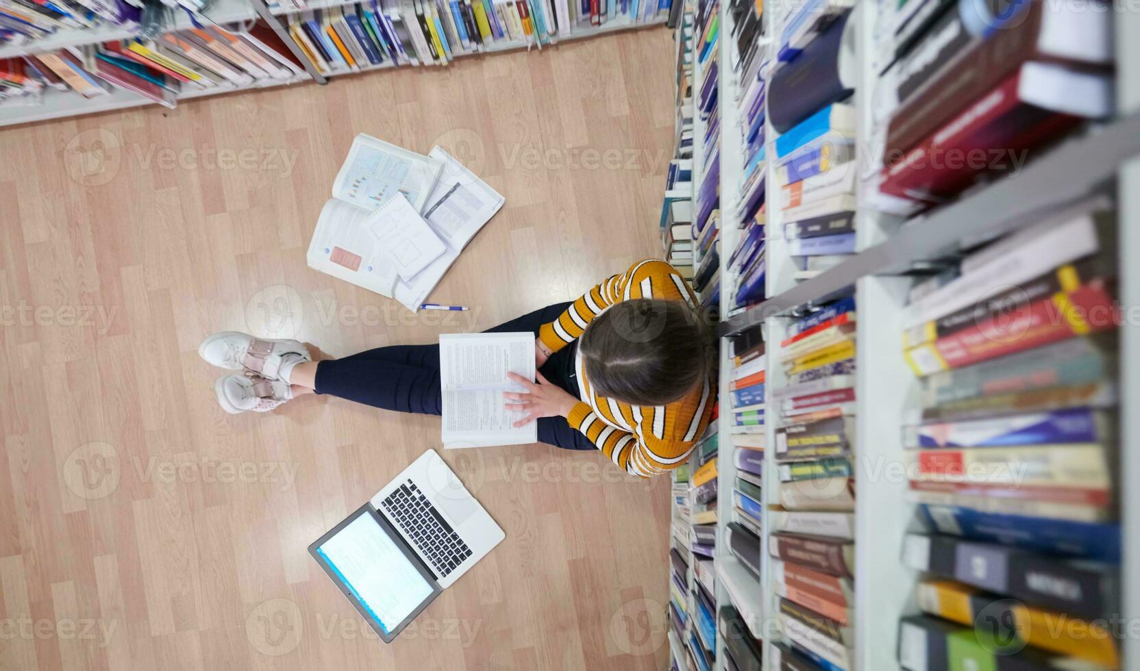 the student uses a notebook and a school library photo