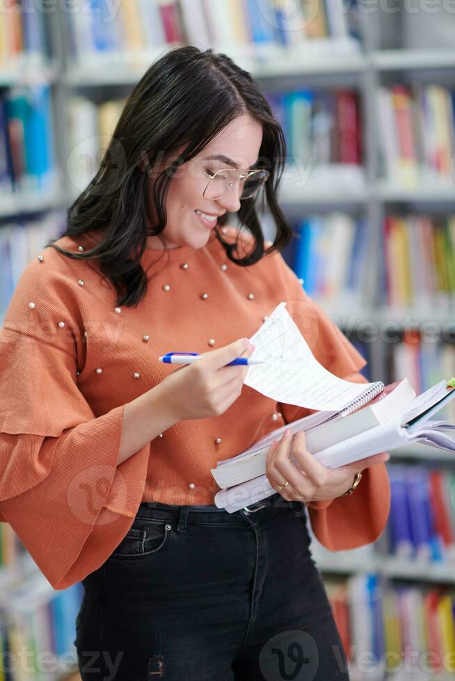 the student uses a notebook and a school library photo