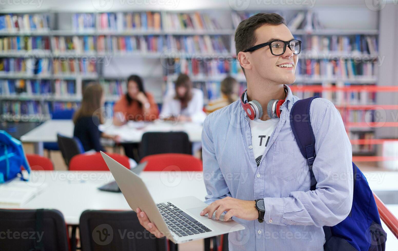 the student uses a notebook, latop and a school library photo