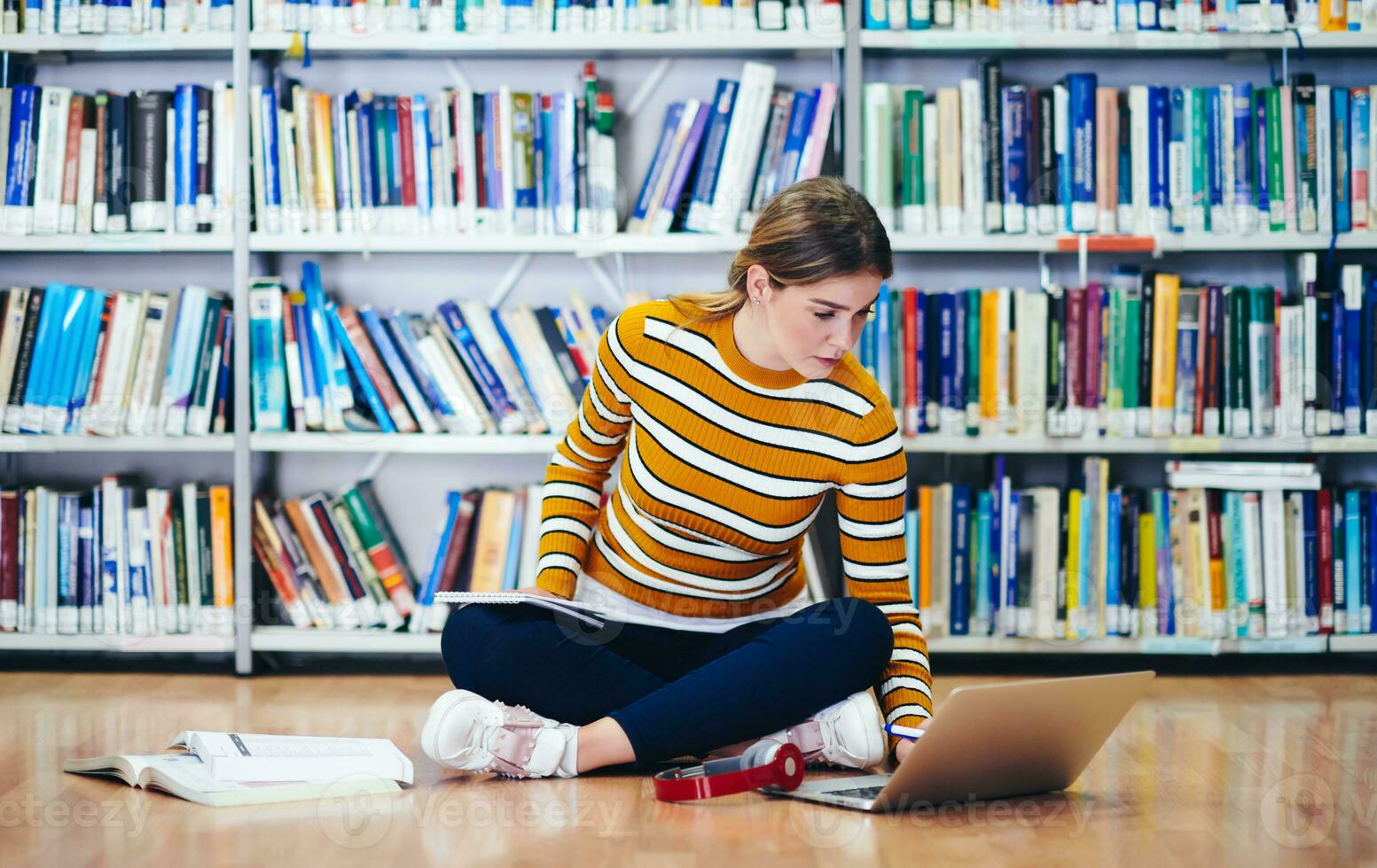 the student uses a notebook and a school library photo