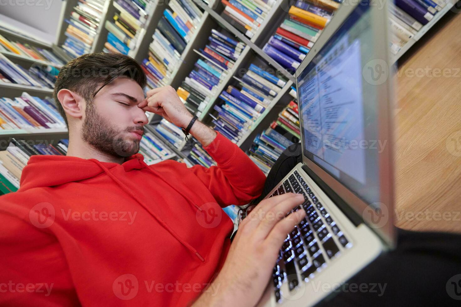 the students uses a notebook, laptop and a school library photo
