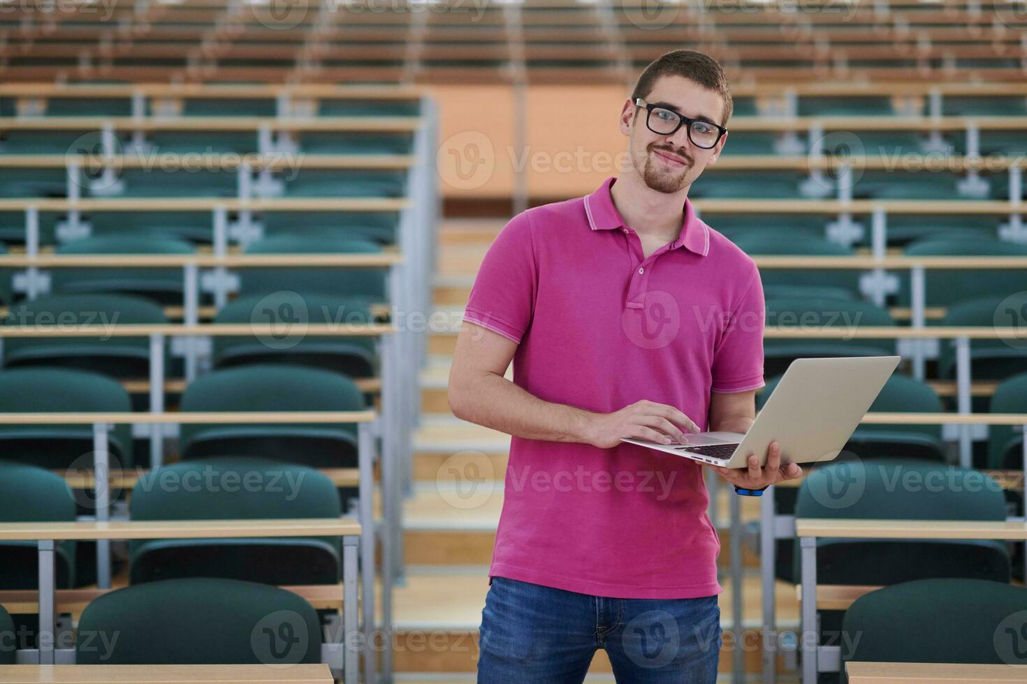 Man student working on laptop in college classroom photo