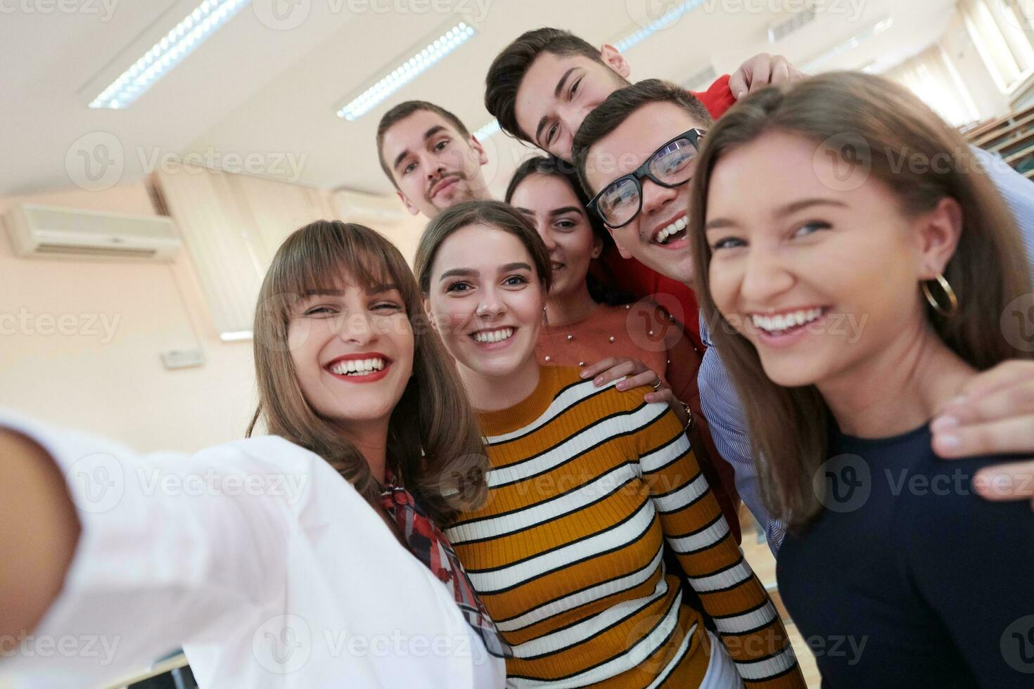 grupo de adolescentes multiétnicos tomando un selfie en la escuela foto