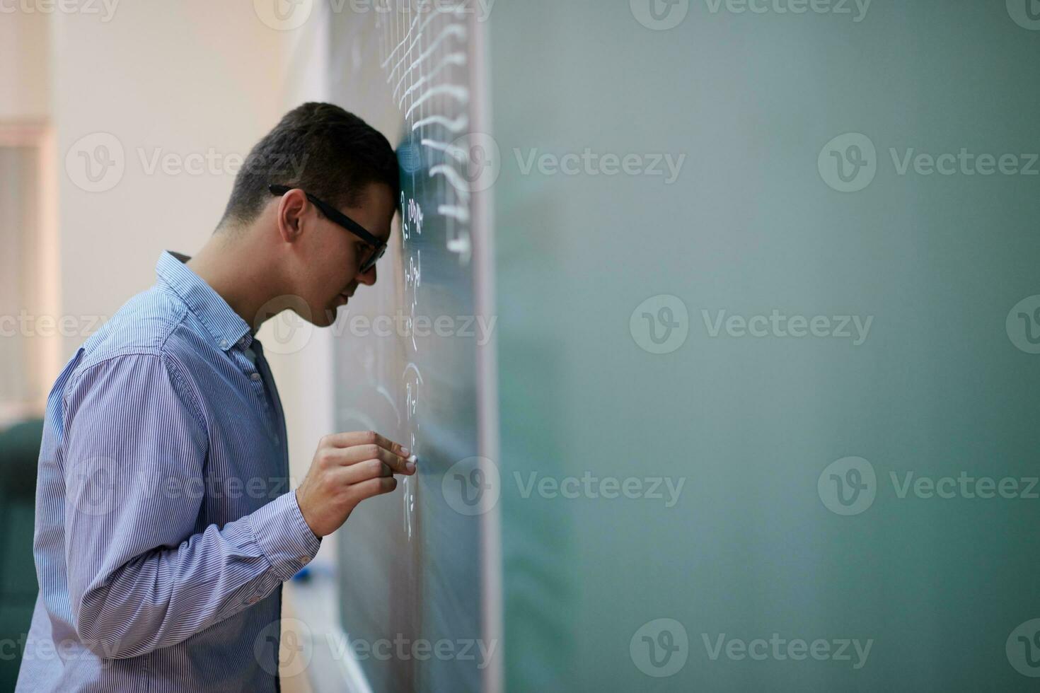 el estudiante hace la tarea en la pizarra foto