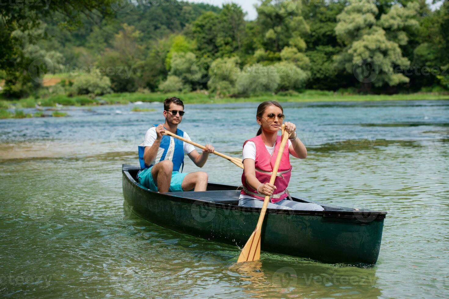 couple of explorers conoining on wild river photo