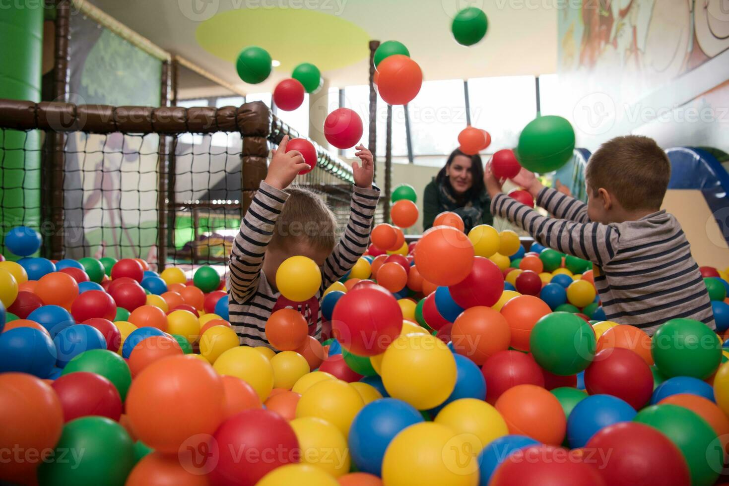 Young mom with her kids in a children's playroom photo