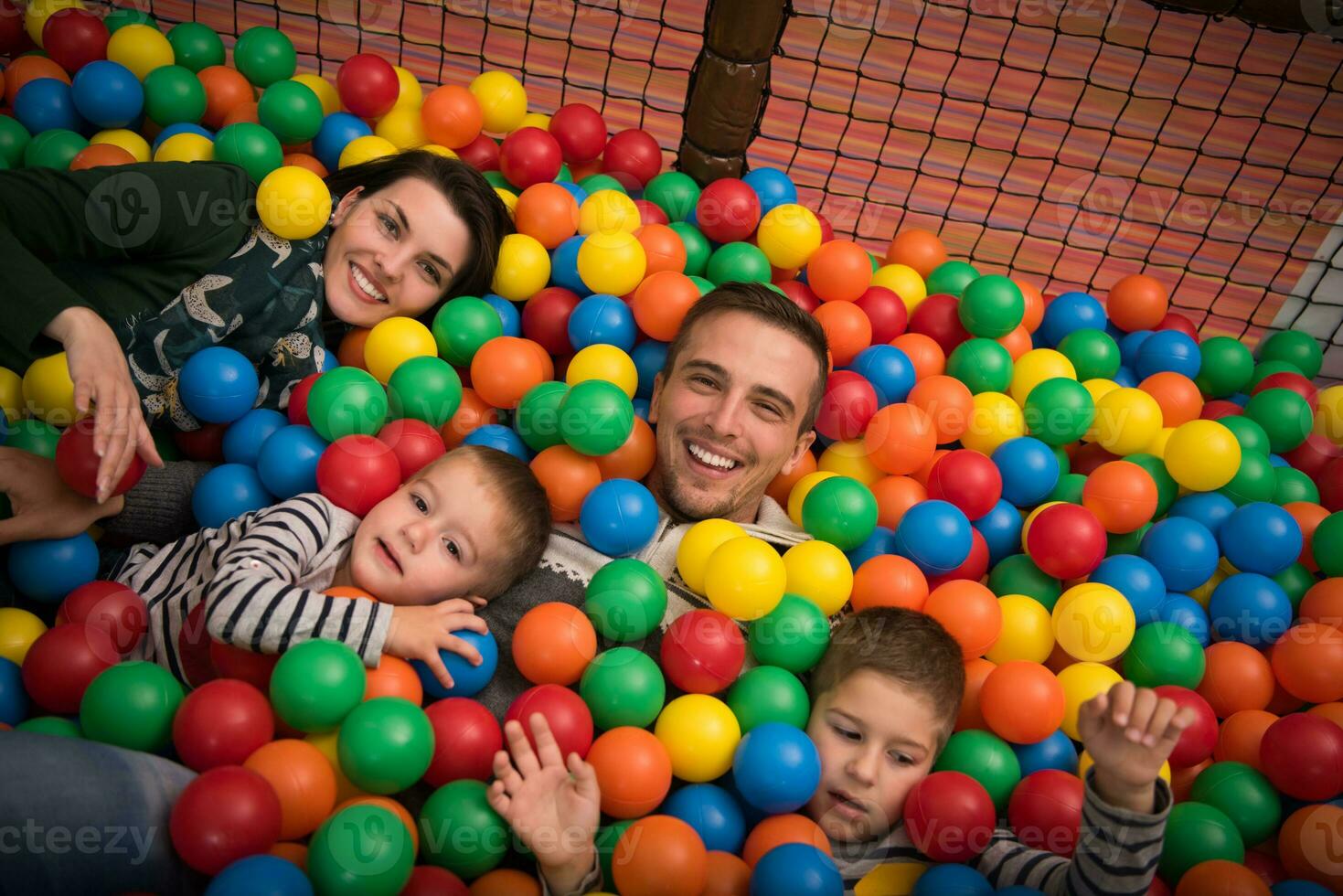 young parents with kids in a children's playroom photo