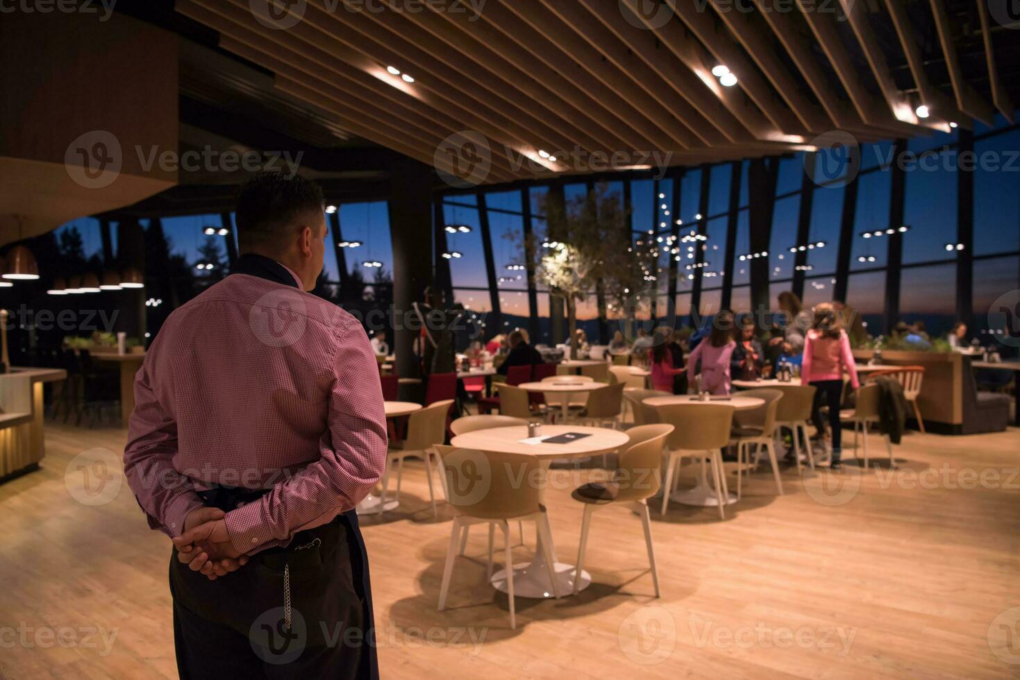 waiter standing with hands behind his back photo
