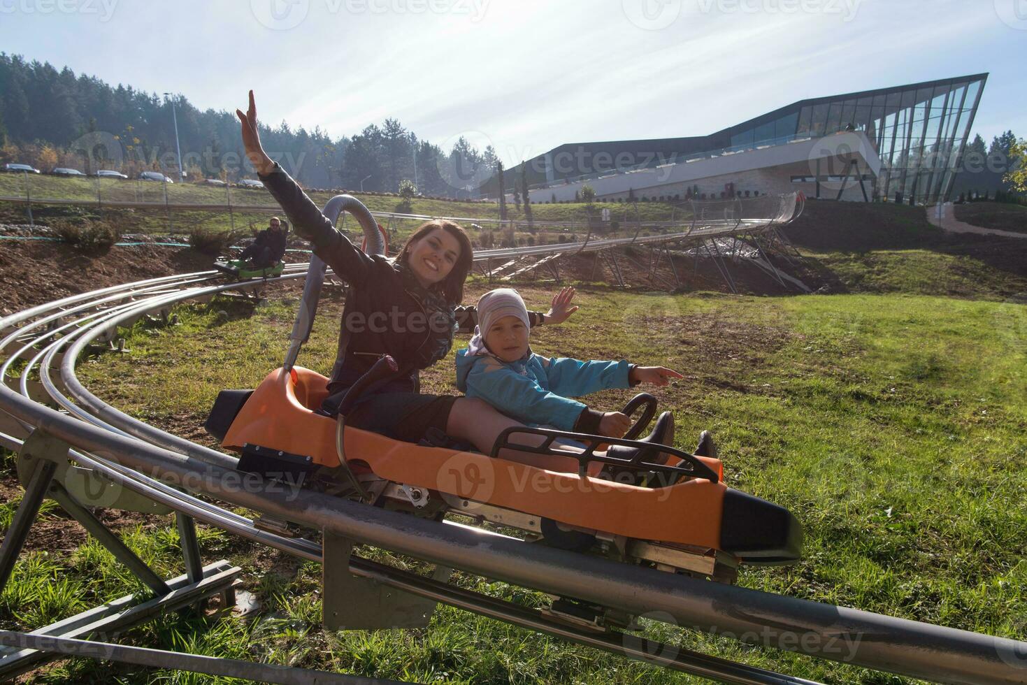 mother and son enjoys driving on alpine coaster photo