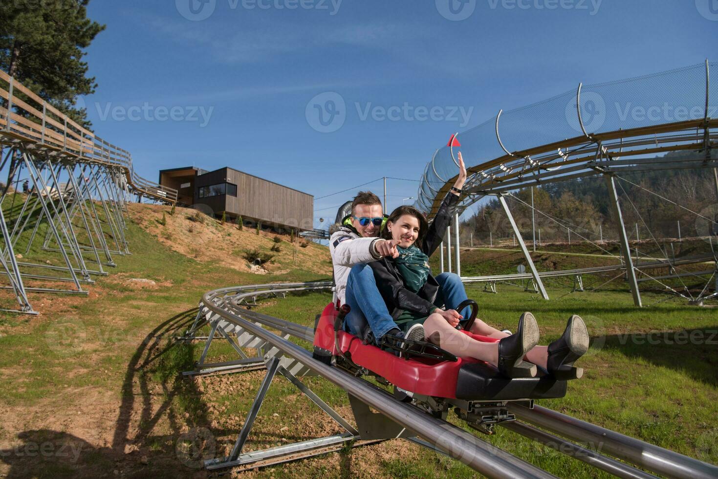 couple enjoys driving on alpine coaster photo