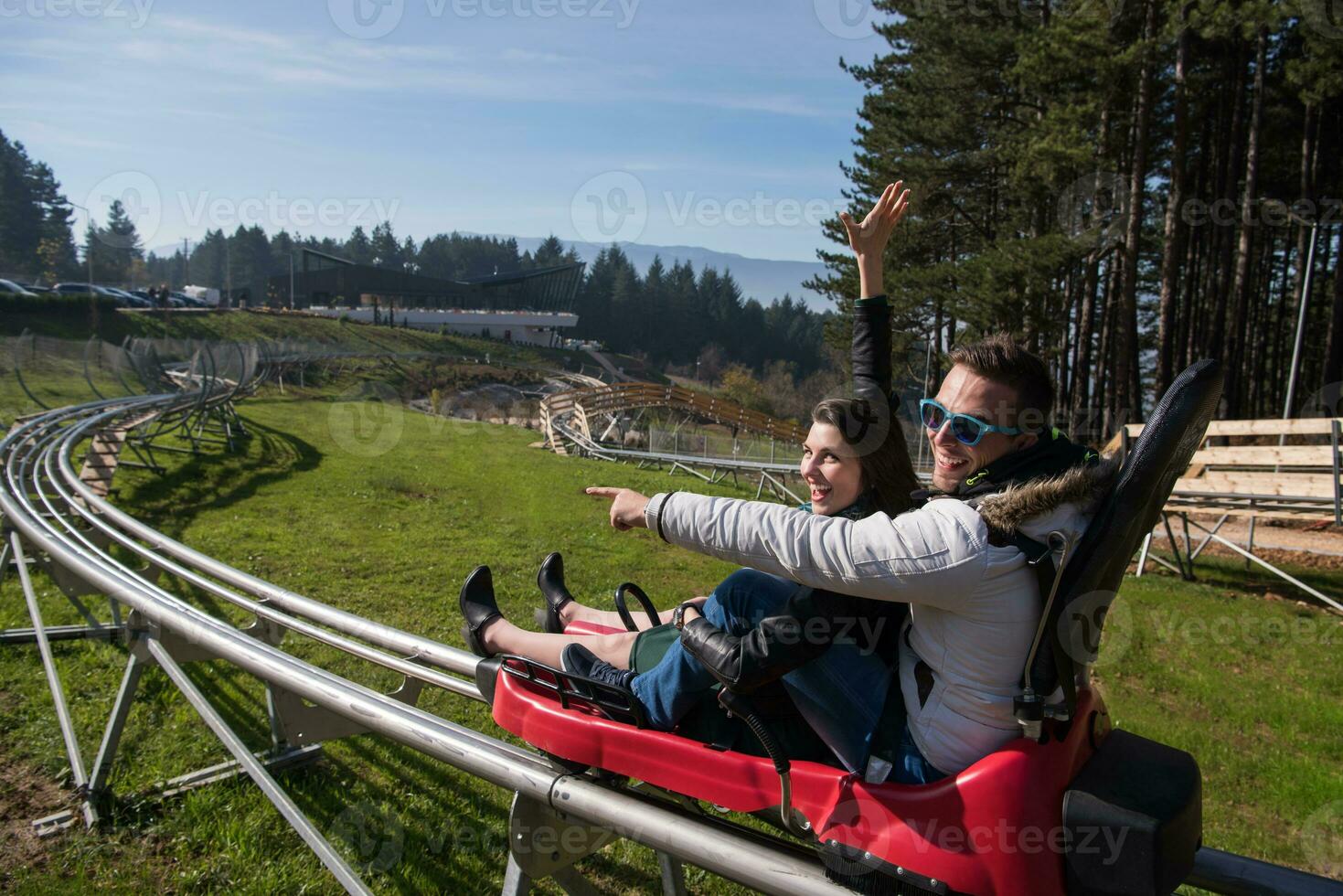 couple enjoys driving on alpine coaster photo