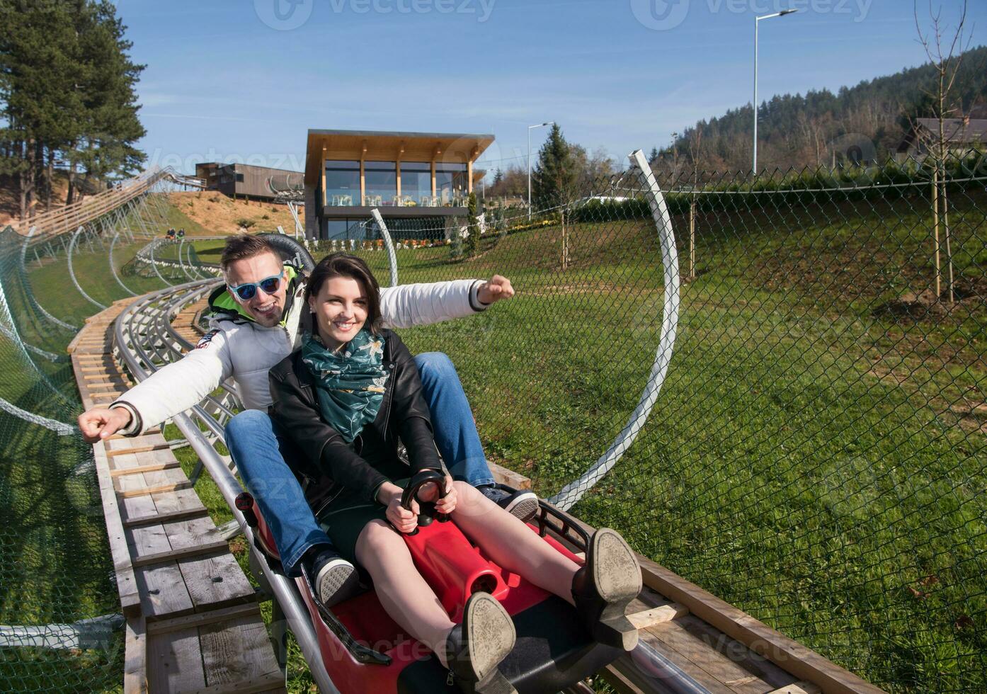 couple enjoys driving on alpine coaster photo