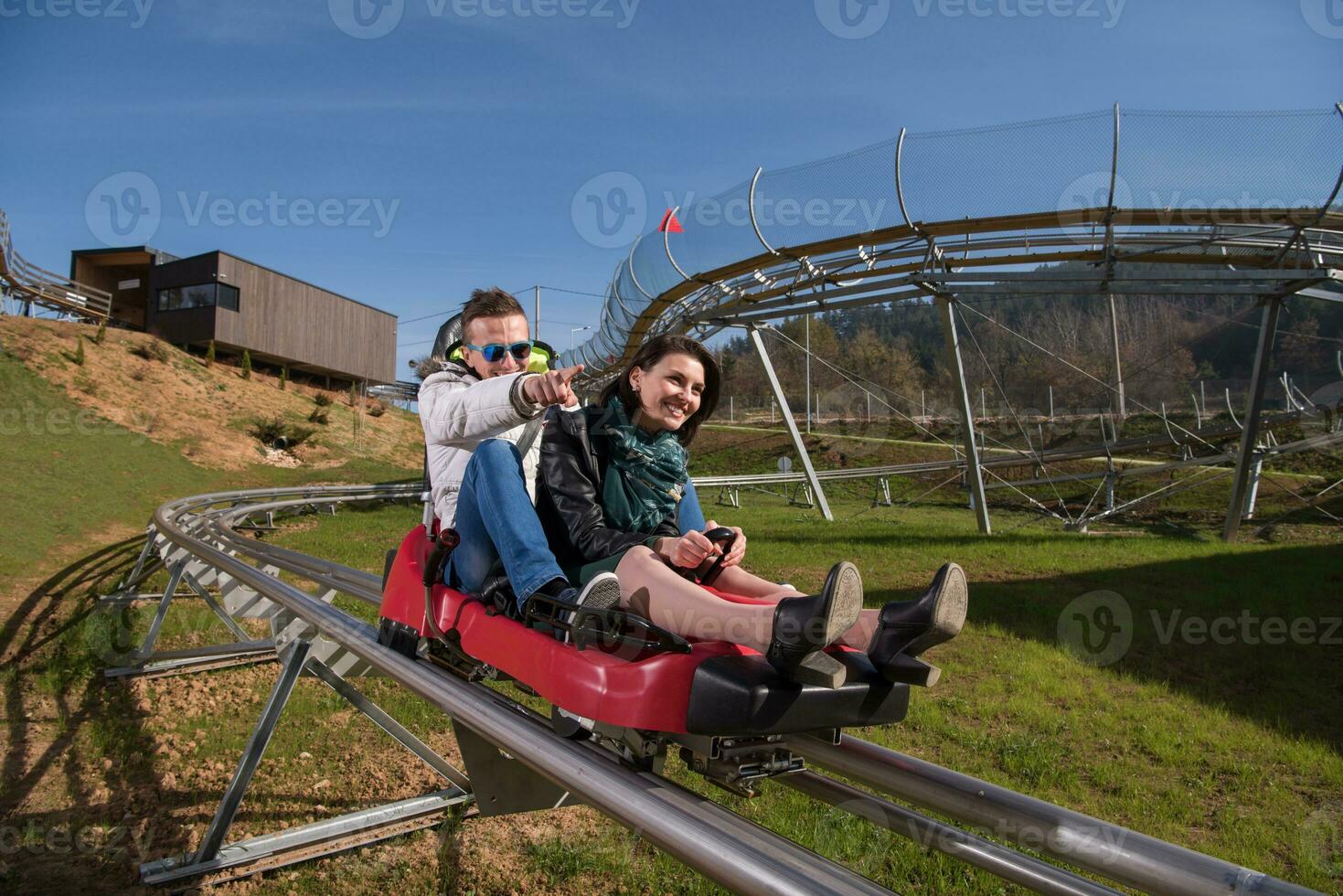 pareja disfruta conduciendo en una montaña rusa alpina foto