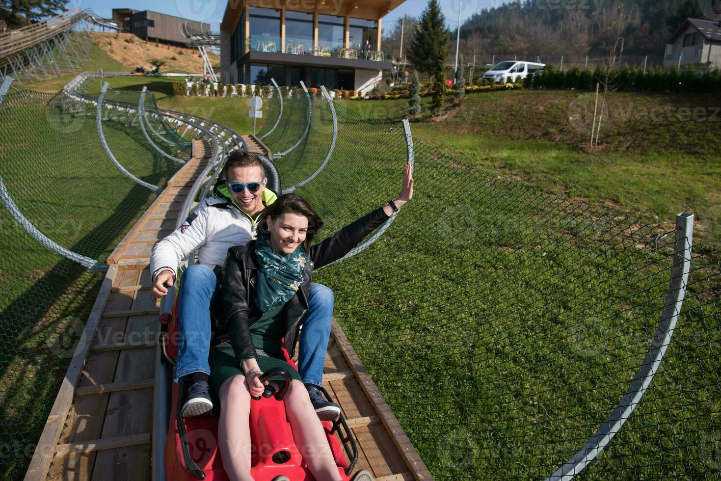 couple enjoys driving on alpine coaster photo