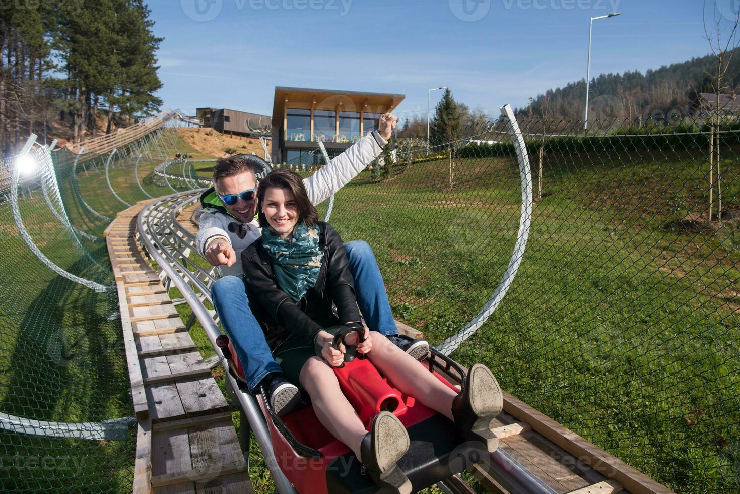 couple enjoys driving on alpine coaster photo