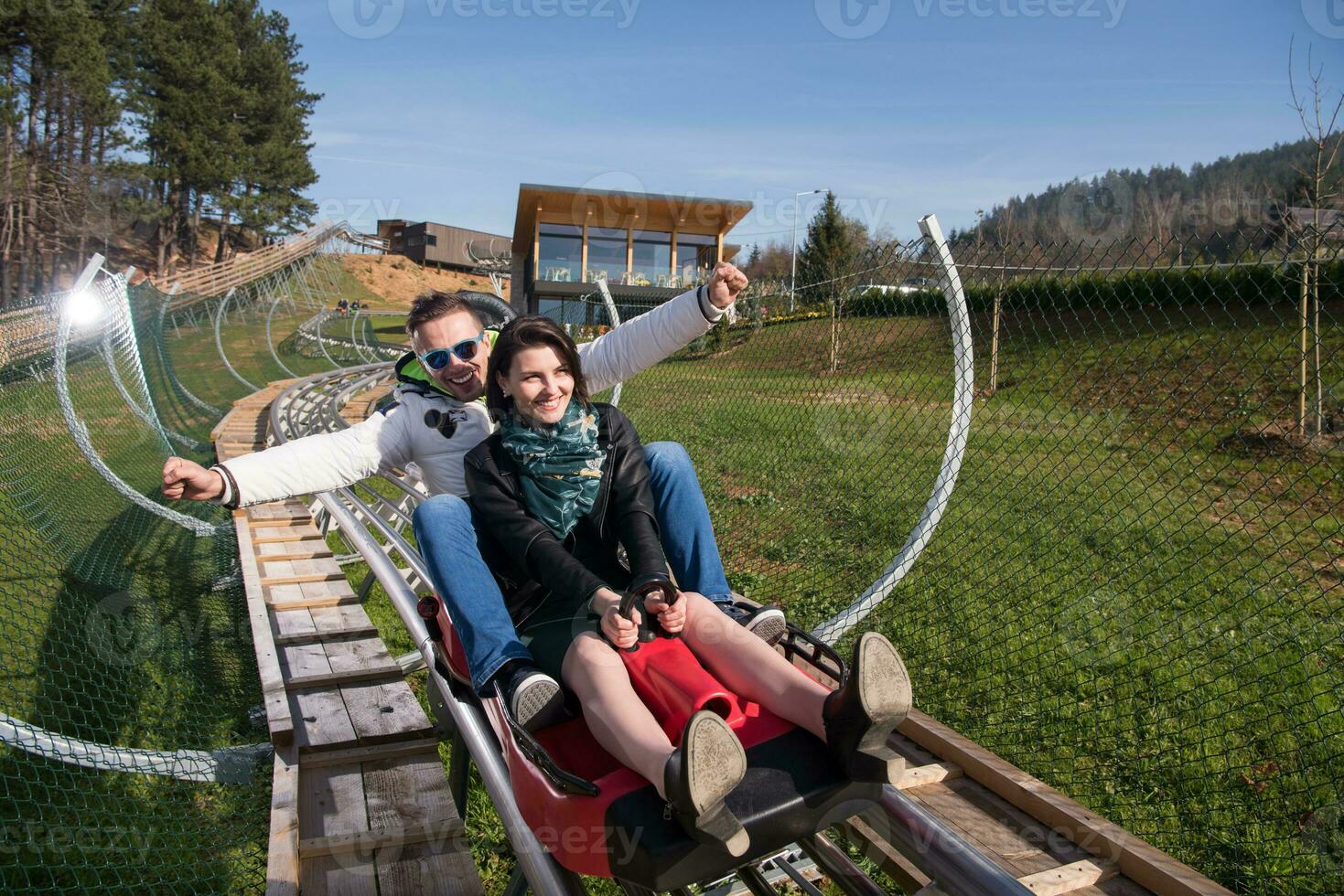 couple enjoys driving on alpine coaster photo