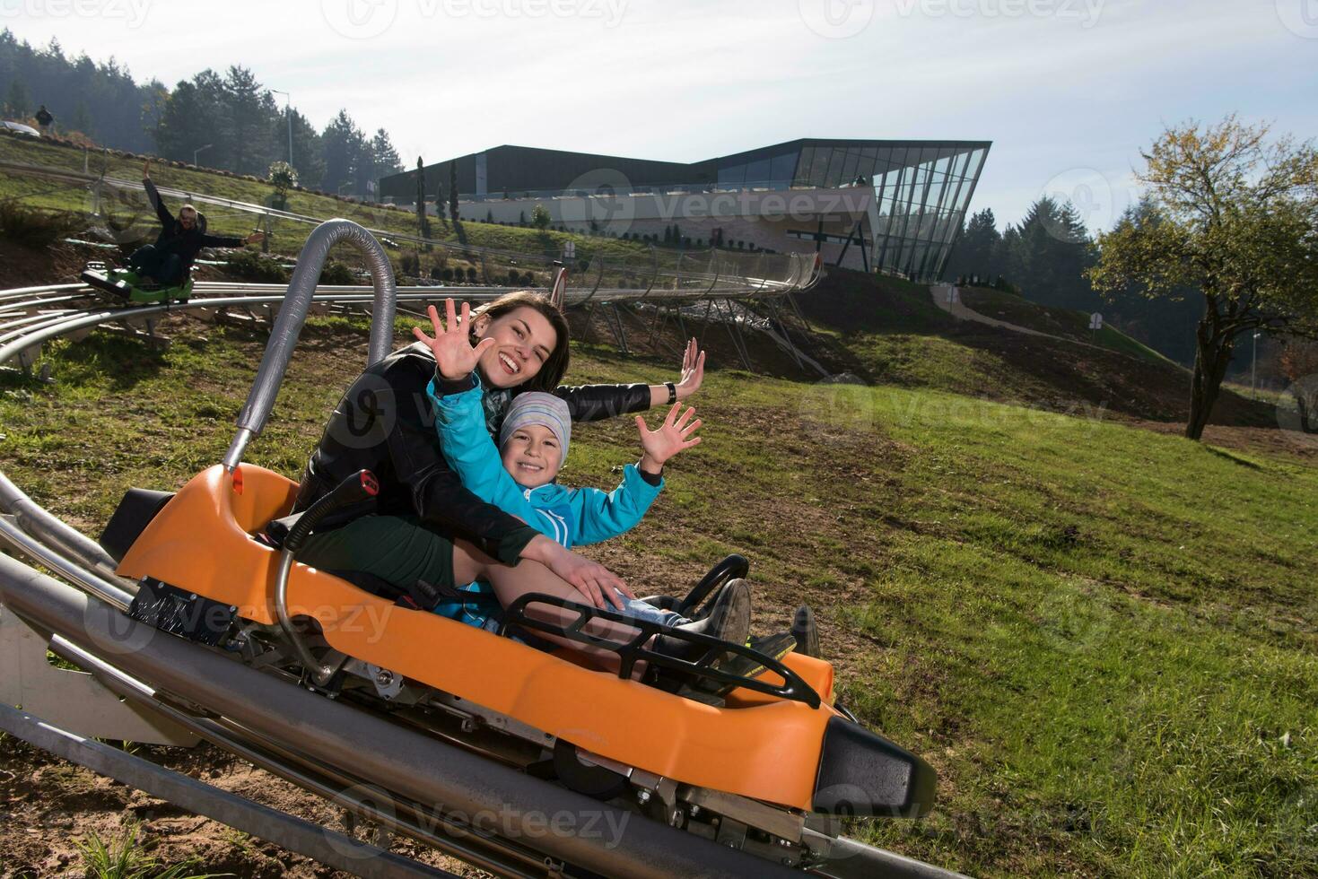 mother and son enjoys driving on alpine coaster photo