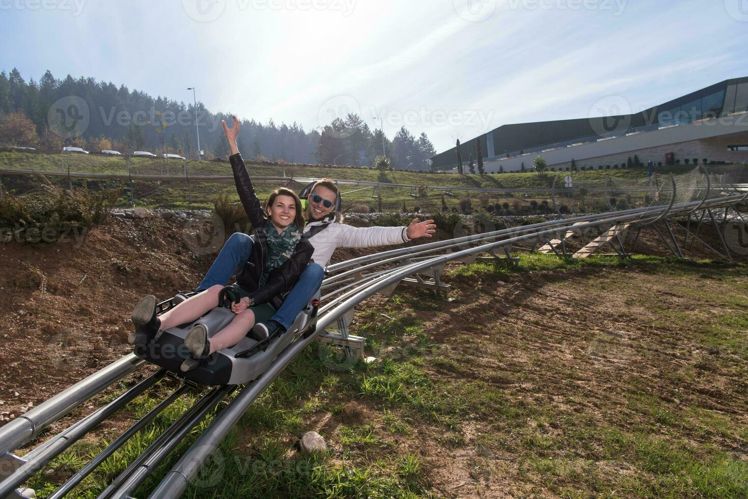 pareja disfruta conduciendo en una montaña rusa alpina foto