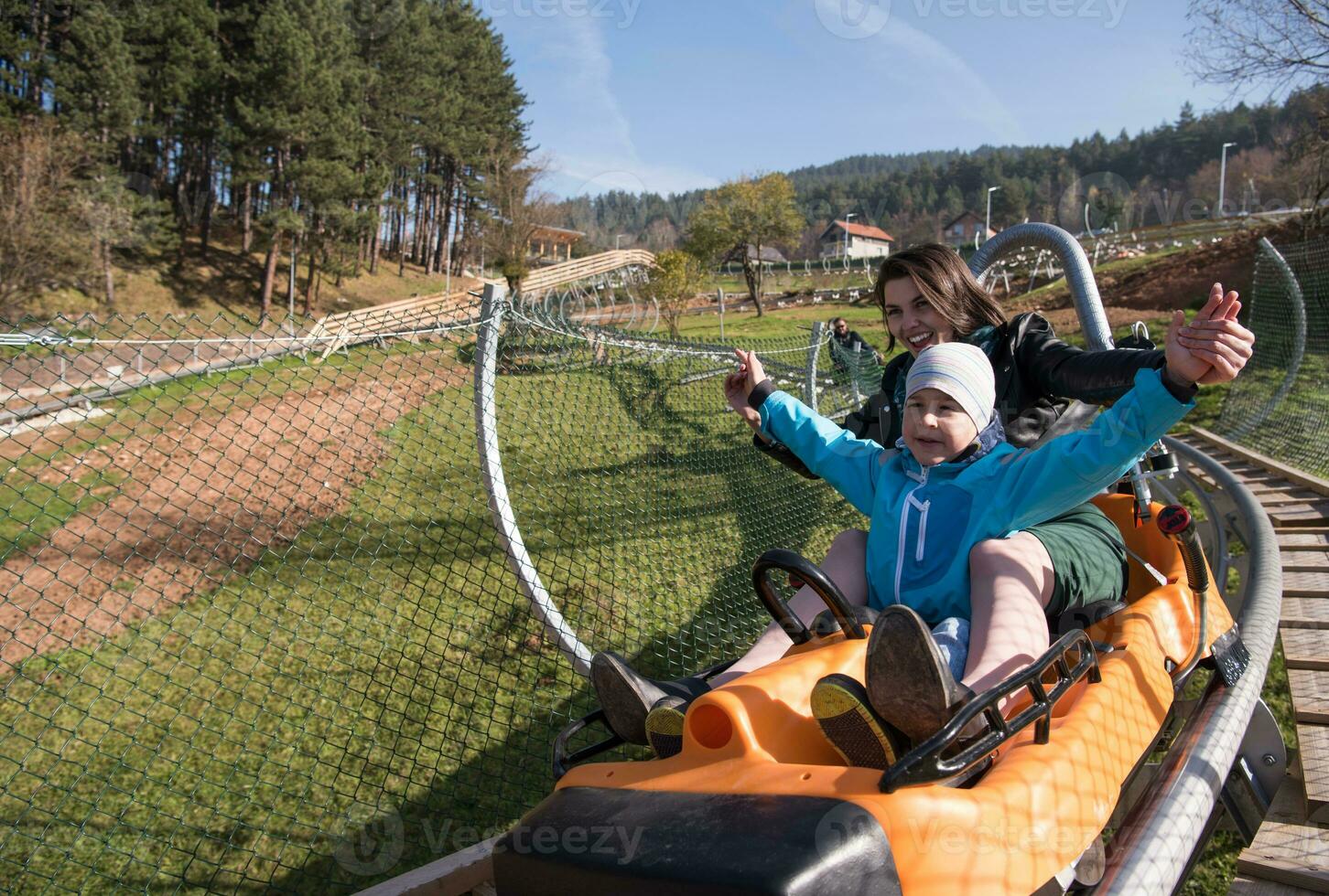 mother and son enjoys driving on alpine coaster photo