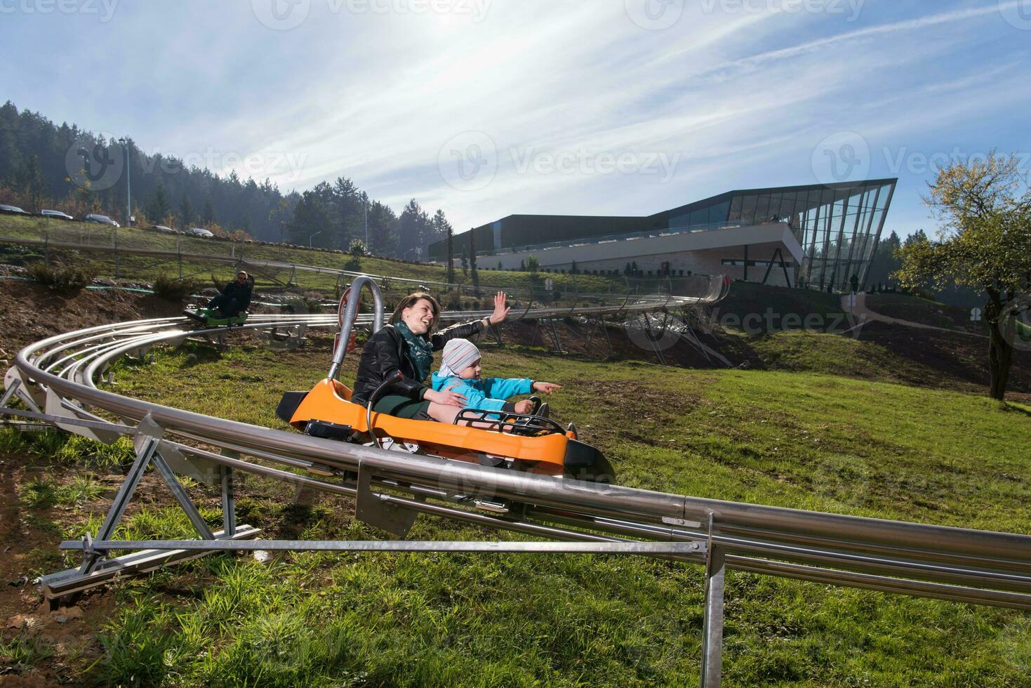 mother and son enjoys driving on alpine coaster photo