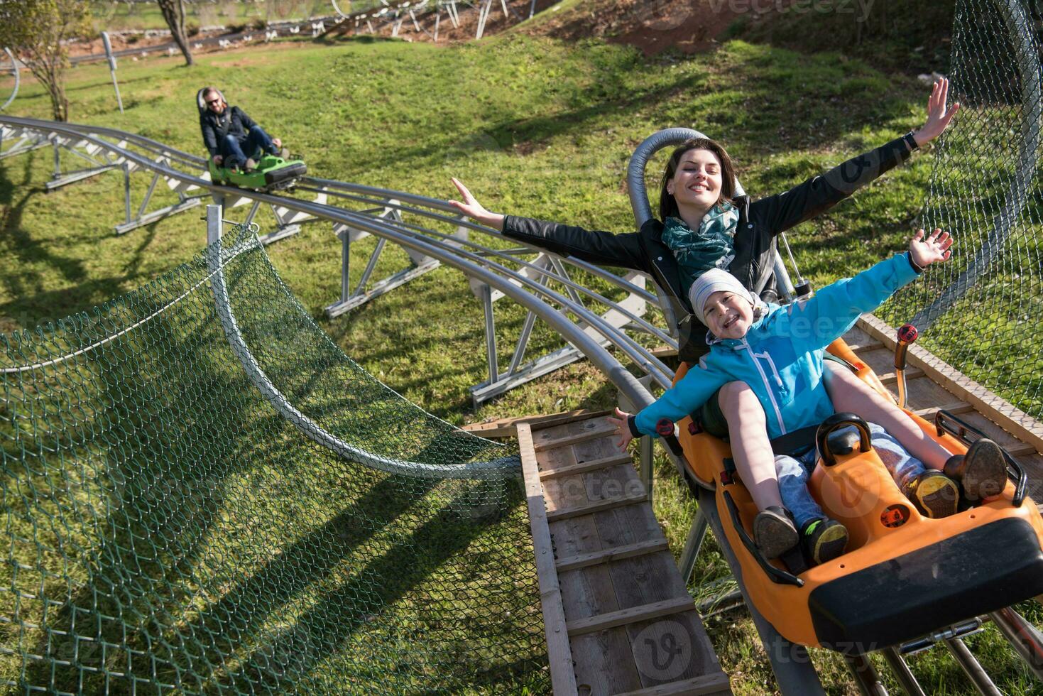 mother and son enjoys driving on alpine coaster photo