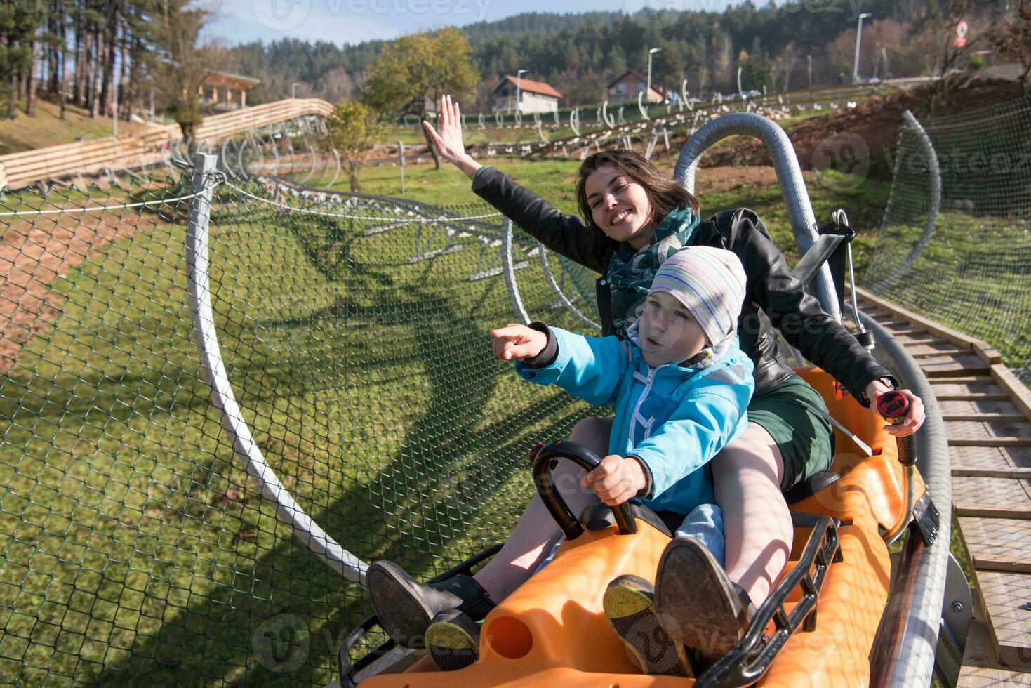 mother and son enjoys driving on alpine coaster photo