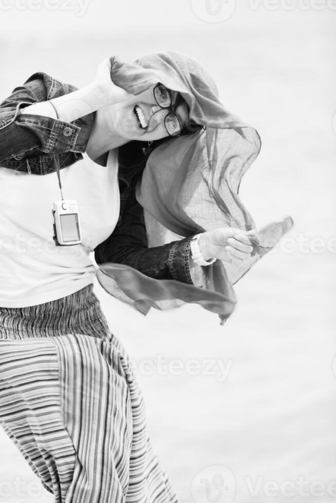 beautiful young woman on beach with scarf photo