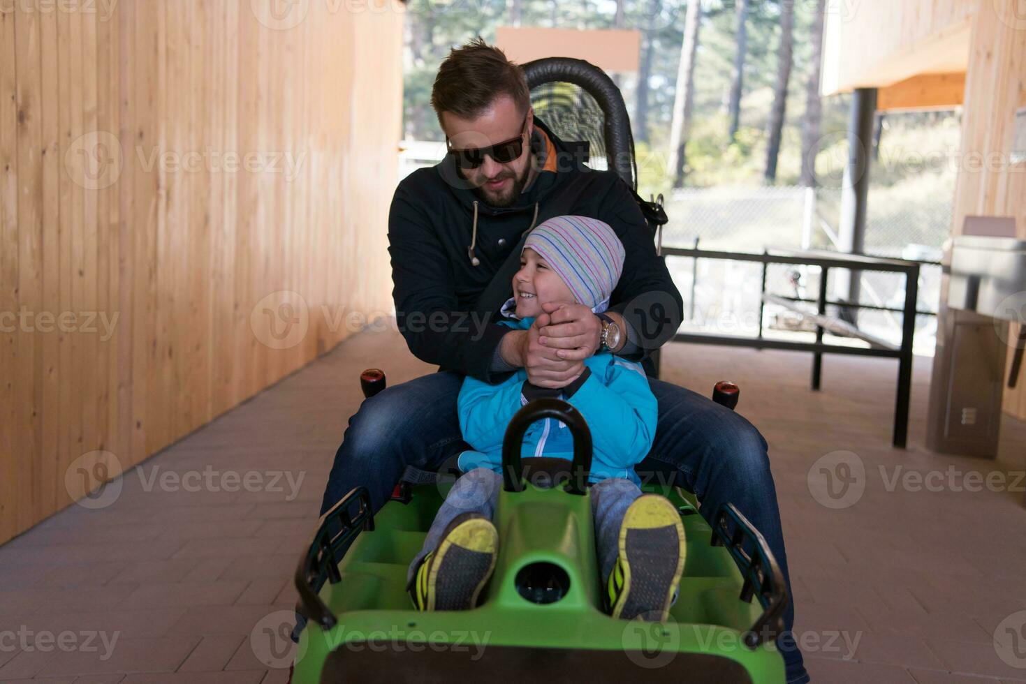 father and son enjoys driving on alpine coaster photo