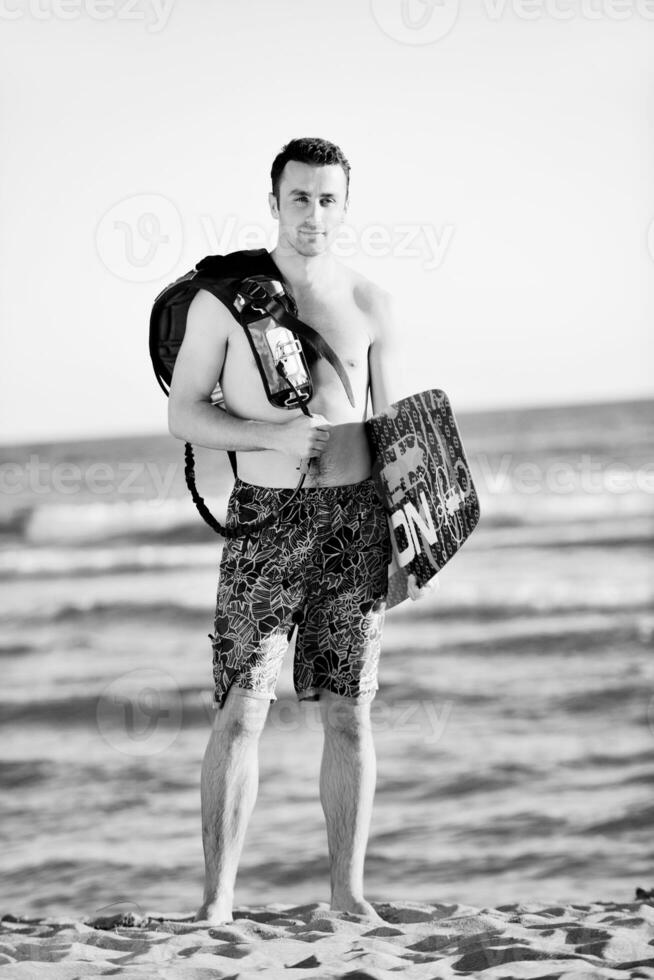 Portrait of a young  kitsurf  man at beach on sunset photo