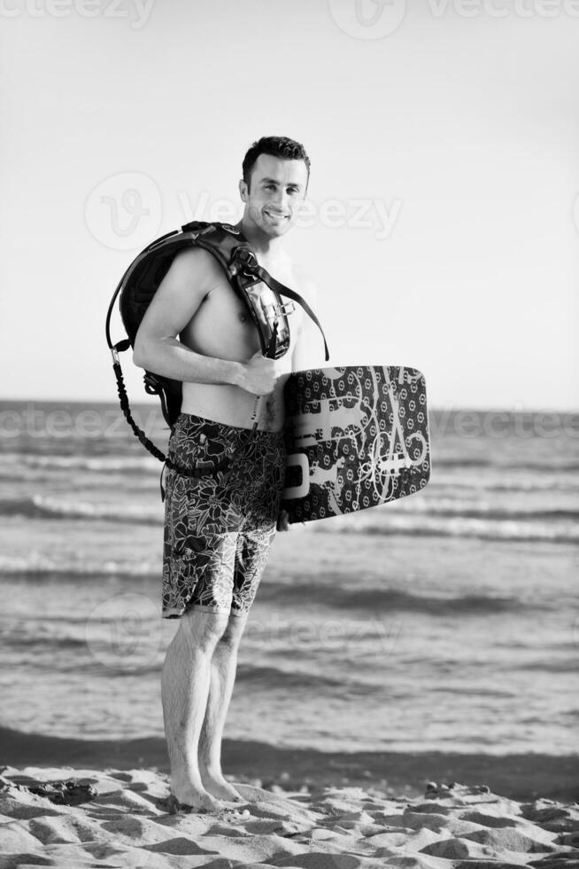 Portrait of a young  kitsurf  man at beach on sunset photo